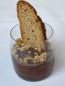 Chocolate pudding garnished with chopped nuts and hazelnut biscotti