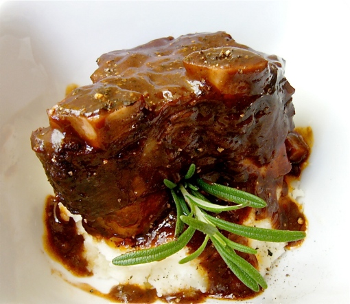 Braised short ribs with mashed potatoes and a rosemary sprig garnish